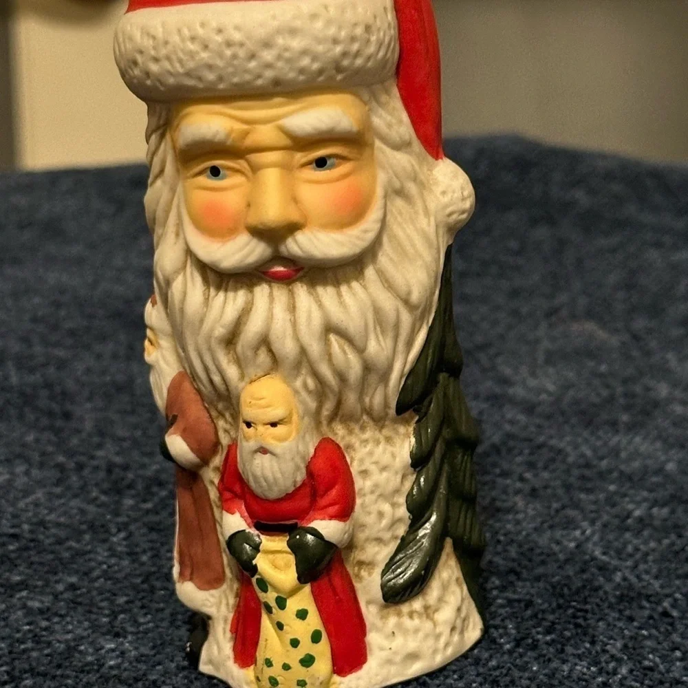Set of 2 Santa candleholders. Each has smaller different smaller Santas.